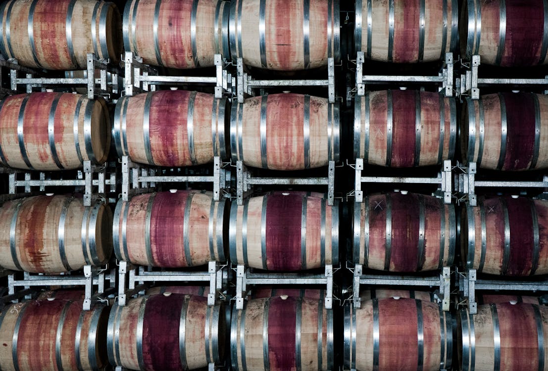Rows of oak wine barrels in a traditional winery cellar