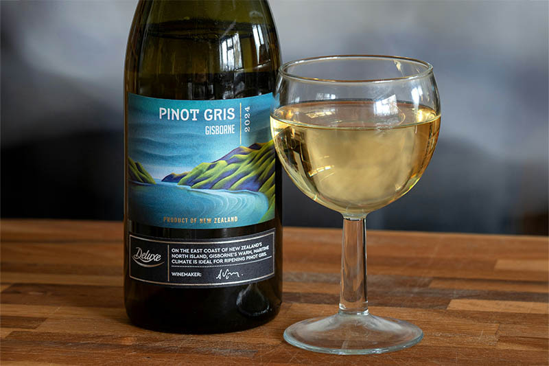 Bottle and glass of white wine on a wooden table - the premium NoLo positioning